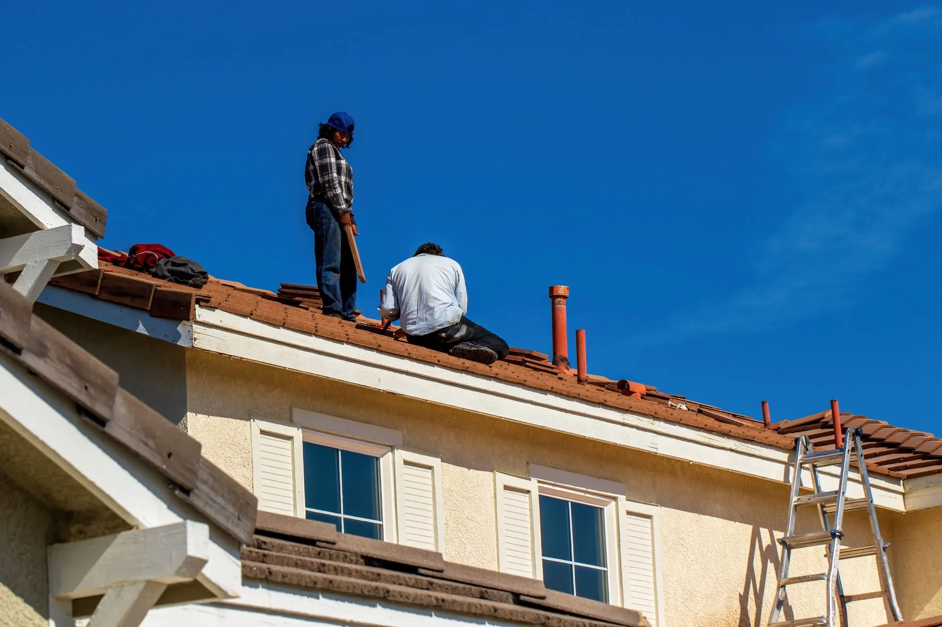 Two Castlegate roofers working on a tiled roof