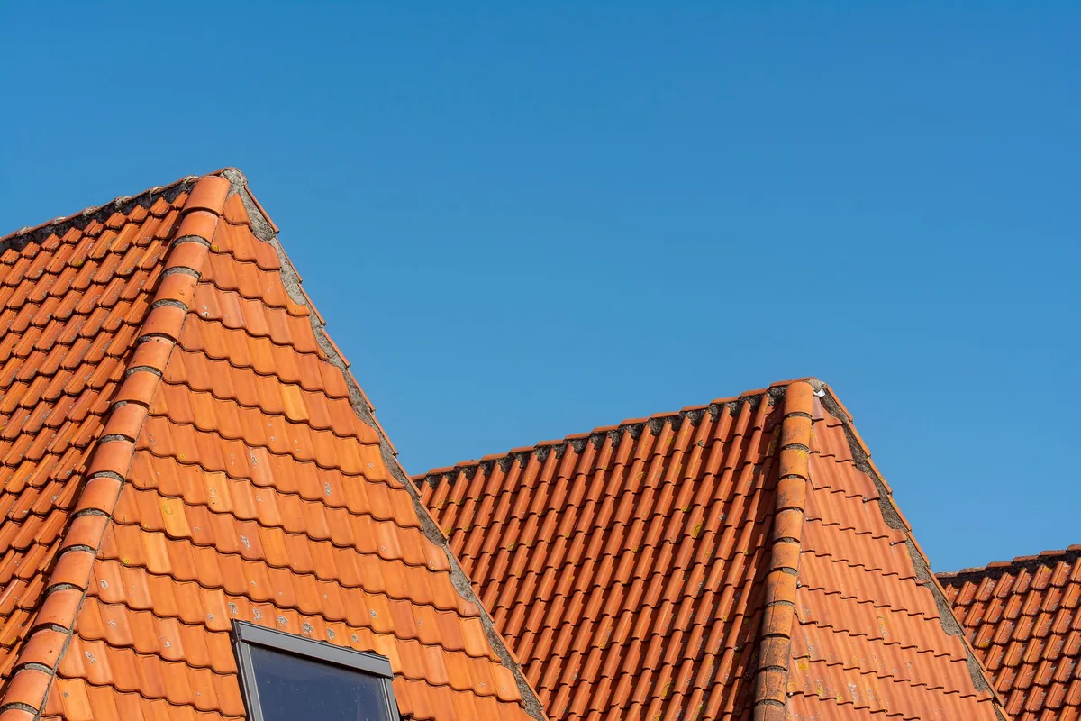 A finished tiled roof under a clear blue sky